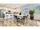 Eat-in kitchen and dining space featuring a white table, black chairs, wood flooring, and ample natural light at 3399 E Open Prairie Dr, San Tan Valley, AZ 85140