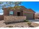 Single-story home featuring a two-car garage, stone accents, and desert landscaping at 3903 E French Trotter St, San Tan Valley, AZ 85140