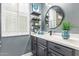 Stylish bathroom vanity features a round mirror, white counter, and sleek gray cabinets at 4121 E Narrowleaf Dr, Gilbert, AZ 85298