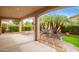 Covered patio with lush tropical landscaping and a rock water feature in the backyard at 4121 E Narrowleaf Dr, Gilbert, AZ 85298