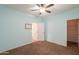 Bedroom features light blue walls, carpeted floor, ceiling fan and access to other rooms at 4135 E Cathy Dr, Gilbert, AZ 85296