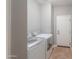 Laundry room with modern washer and dryer units, tile floor and a white door at 4135 E Cathy Dr, Gilbert, AZ 85296