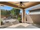 Covered back patio with a ceiling fan leading to a stone-covered yard and brick paver patio at 44087 W Granite Dr, Maricopa, AZ 85139