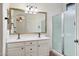 Bright bathroom featuring a double vanity, large mirror, modern lighting, and a walk-in shower at 44087 W Granite Dr, Maricopa, AZ 85139