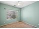 Simple bedroom with green walls, carpet, ceiling fan, and a window overlooking the yard at 44087 W Granite Dr, Maricopa, AZ 85139