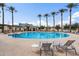 Resort-style community pool with lounge chairs and covered cabanas surrounded by palm trees at 44087 W Granite Dr, Maricopa, AZ 85139