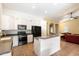 Modern kitchen with white cabinets, black appliances, gray countertops and a view into living room at 44087 W Granite Dr, Maricopa, AZ 85139