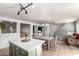 Bright kitchen and dining area featuring a large island, modern lighting, and neutral tones at 44961 W Miraflores St, Maricopa, AZ 85139