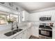 Bright kitchen with stainless steel appliances, granite countertops, and a view from the window at 44961 W Miraflores St, Maricopa, AZ 85139