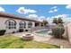 Backyard with a pool, lush lawn, fire pit, and arched windows for outdoor living at 4618 E Carriage Ct, Gilbert, AZ 85297