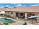 An open backyard showcases a pool, covered patio, and a seating area with shade at 4618 E Carriage Ct, Gilbert, AZ 85297