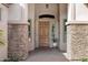 Inviting front entrance with a solid wood door, stone accents, sidelights and brick pavers at 4618 E Carriage Ct, Gilbert, AZ 85297