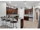 Open kitchen featuring dark wood cabinetry, tiled backsplash, granite counters, and breakfast bar at 4618 E Carriage Ct, Gilbert, AZ 85297