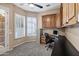 Bright office features built-in desk and cabinets, a ceiling fan, and natural light from the shuttered windows at 4618 E Carriage Ct, Gilbert, AZ 85297