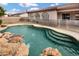 A backyard pool with stone waterfall and steps offers a refreshing oasis at 4618 E Carriage Ct, Gilbert, AZ 85297