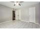 Bedroom showcasing tiled floors, ceiling fan, and double doors leading into the hallway at 5115 W Surrey Ave, Glendale, AZ 85304