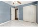 A neutral bedroom with white tiled floors, with a large closet and ceiling fan at 5115 W Surrey Ave, Glendale, AZ 85304