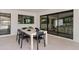 Outdoor dining area with black-framed sliding glass doors, brick wall, and modern furniture at 5819 E Ludlow Dr, Scottsdale, AZ 85254