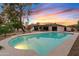 Backyard sunset view of a sparkling pool, patio area, and the home, creating a serene atmosphere for outdoor living at 5819 E Ludlow Dr, Scottsdale, AZ 85254