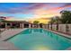 Backyard pool at sunset, providing a relaxing view with landscaping, an outdoor dining area, and a lush green area at 5819 E Ludlow Dr, Scottsdale, AZ 85254