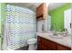 Cozy bathroom with zig-zag shower curtain, wood cabinet, and sink with marble countertops at 6237 E Inglewood St, Mesa, AZ 85205