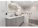 Modern bathroom featuring double vanity, white marble tiling, and separate shower at 6237 E Inglewood St, Mesa, AZ 85205