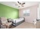 Comfortable bedroom featuring a bed, ceiling fan, chair, and large windows for natural light at 6237 E Inglewood St, Mesa, AZ 85205