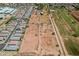 Aerial image showing acreage of land next to residential houses and fields that have potential for development at 6648 S 27Th Ave, Phoenix, AZ 85041