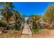 Beautiful pond featuring a small dock with boat, surrounded by lush greenery and palm trees, creating a tranquil oasis at 6648 S 27Th Ave, Phoenix, AZ 85041