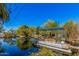 Serene pond with a boat dock, surrounded by trees, creating a peaceful retreat and a refreshing escape at 6648 S 27Th Ave, Phoenix, AZ 85041