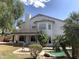 This backyard features a pool with tropical landscaping, a seating area, and a stucco home with a second story balcony at 6834 E Culver St, Mesa, AZ 85207