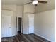 Empty bedroom featuring wood floors, neutral paint, ceiling fan and three doors at 6834 E Culver St, Mesa, AZ 85207