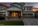 Beautiful two-story home with a brick and stone facade and a well-manicured front lawn at twilight at 717 E Deer Creek Rd, Phoenix, AZ 85048