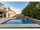 Luxurious pool area with a waterfall, lush landscaping, and outdoor kitchen, perfect for relaxation at 717 E Deer Creek Rd, Phoenix, AZ 85048