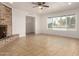 Bright living room featuring tile floors, a ceiling fan, a large brick fireplace, and recessed lighting at 8014 N 55Th Ave, Glendale, AZ 85302