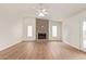 Bright living room featuring hardwood floors, a ceiling fan, and a cozy stone fireplace at 812 W Rosal Pl, Chandler, AZ 85225