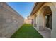 Artificial grass, covered patio with arches, and a brick wall offer a private backyard oasis at 919 S Pheasant Dr, Gilbert, AZ 85296