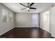 Bright bedroom with dark floors, large windows with curtains, ceiling fan, and neutral wall paint at 919 S Pheasant Dr, Gilbert, AZ 85296