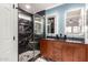 Modern bathroom featuring a walk-in shower with dark marble surround, dual sinks and wood cabinets at 930 W Hudson Way, Gilbert, AZ 85233