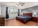 Main bedroom with a king bed, ceiling fan and dark curtains for privacy at 930 W Hudson Way, Gilbert, AZ 85233