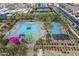 Aerial view of the community pool with a slide, splash pad, lounge seating and lush landscaping throughout the community at 9918 E Tahoe Ave, Mesa, AZ 85212