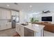 Modern open concept kitchen with stainless steel appliances and island with countertop seating at 9918 E Tahoe Ave, Mesa, AZ 85212