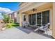 Covered patio with stylish outdoor seating, ceiling fan, and sliding glass doors at 9918 E Tahoe Ave, Mesa, AZ 85212