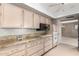 Well-equipped kitchen featuring granite countertops, ceiling fan, ample cabinet space and modern appliances at 9946 W Willow Creek Cir, Sun City, AZ 85373