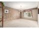 Inviting living area featuring carpeted floors, chandelier lighting, and a large window with scenic views at 9946 W Willow Creek Cir, Sun City, AZ 85373