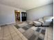 Cozy living room featuring neutral-toned tile flooring and a comfortable armchair with an ottoman at 1210 E Marny Rd, Tempe, AZ 85288
