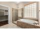 Luxurious bathroom featuring a glass-enclosed shower, soaking tub, and a walk in closet at 12852 W El Sueno Dr, Sun City West, AZ 85375