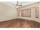 Spacious bedroom featuring wood-look floors, ceiling fan, and shuttered windows for natural light at 12852 W El Sueno Dr, Sun City West, AZ 85375