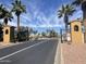 Gated entrance to a community lined with mature palm trees and landscaped grounds at 12852 W El Sueno Dr, Sun City West, AZ 85375