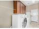 Well-lit laundry room with ample storage cabinets and modern, front-loading washer and dryer units at 12852 W El Sueno Dr, Sun City West, AZ 85375